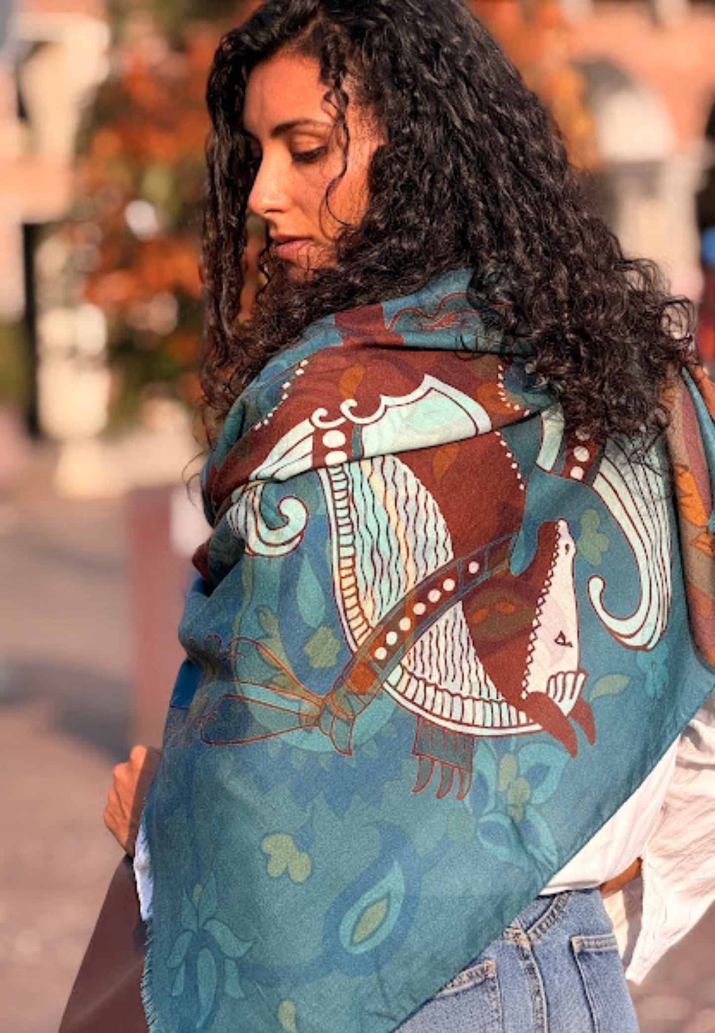 Woman wearing a colorful patterned shawl with abstract designs.Material : Cashmere Wool Silk Scarf , Made in Italy