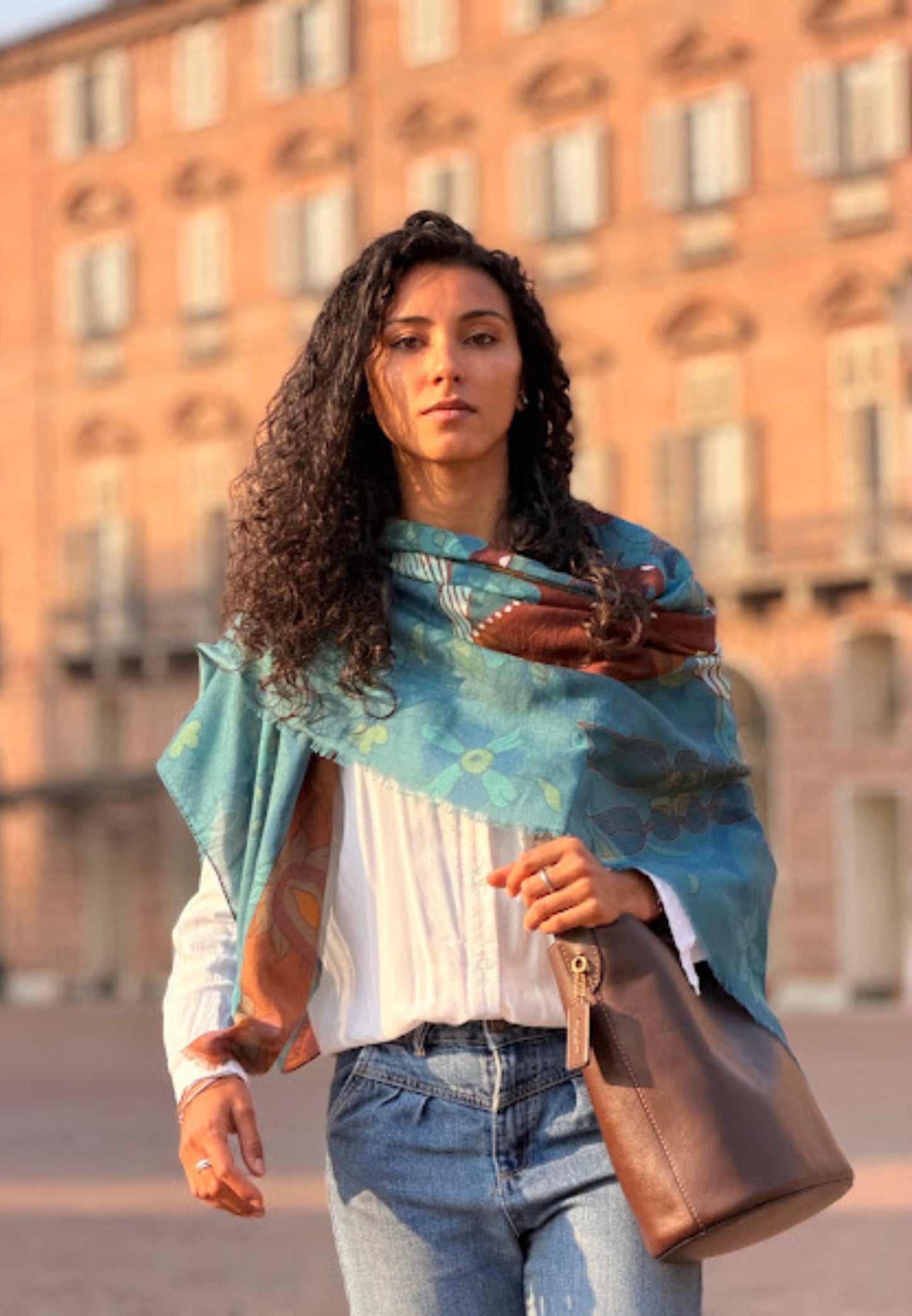 Woman wearing a colorful patterned shawl with abstract designs.Material : Cashmere Wool Silk Scarf , Made in Italy