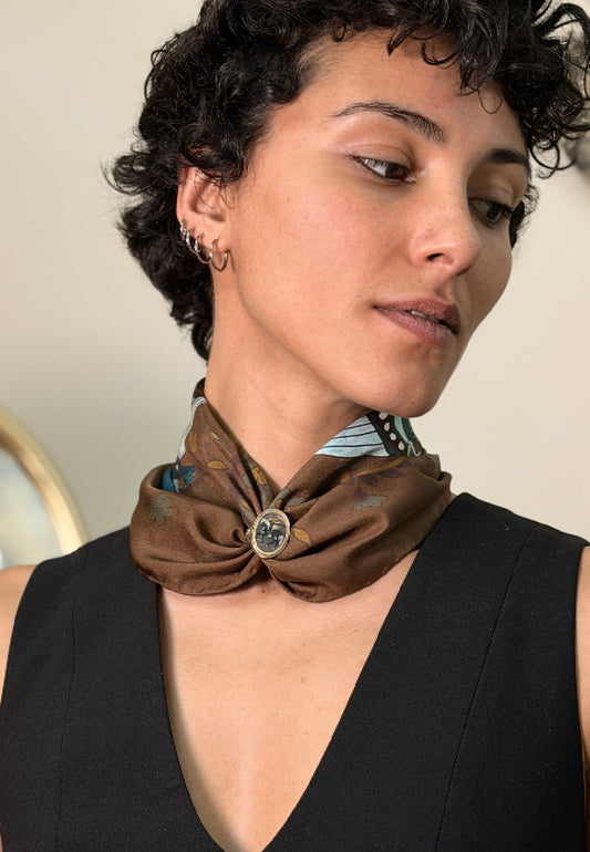 A close-up of a woman wearing a brown silk tied with pari-dar ilver ring